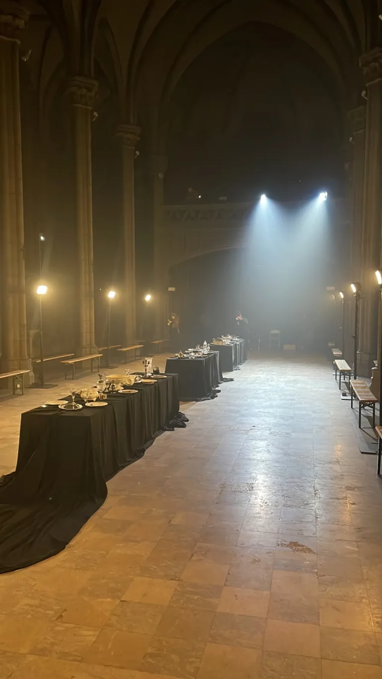 Défilé Algieri Paris dans une église : faisceaux lumineux, projecteurs sur pied et tables drapées de noir – éclairage Pandora Event