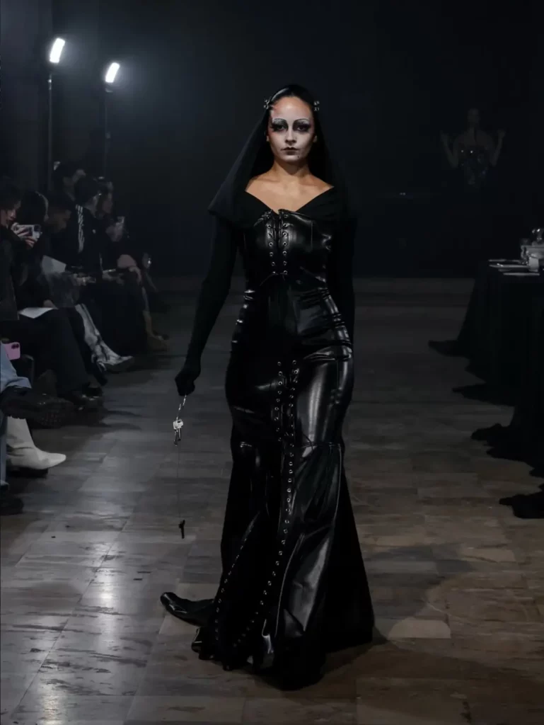 Défilé Algieri Paris, Fashion Week janvier 2026 : robe longue en cuir noir lacée sur le podium, lumière et son Pandora Event
