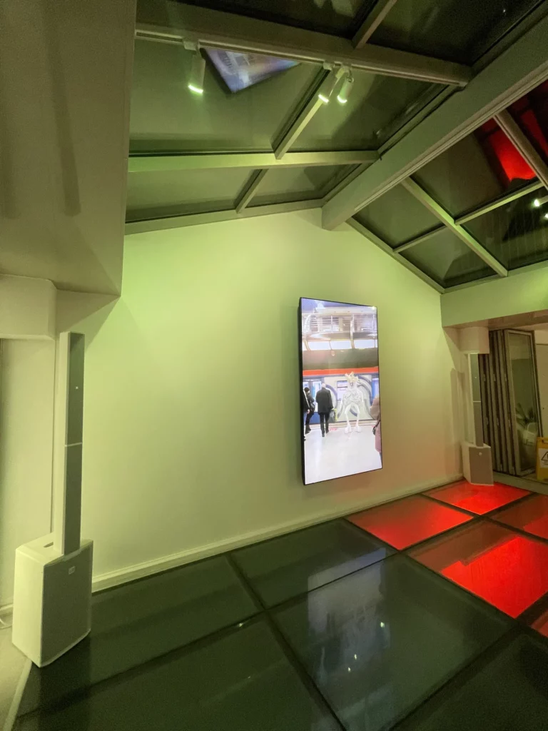 Salle sous verrière de l’exposition Jenna Marvin : écran vidéo et éclairage vert et rouge – Pandora Event